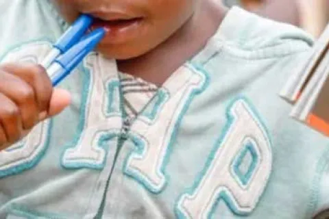 little boy chewing on pens