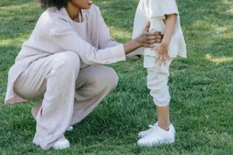 mother kneeling down to talk to her child outside