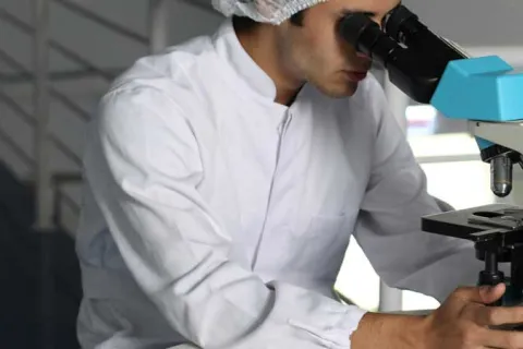 researcher using a microscope