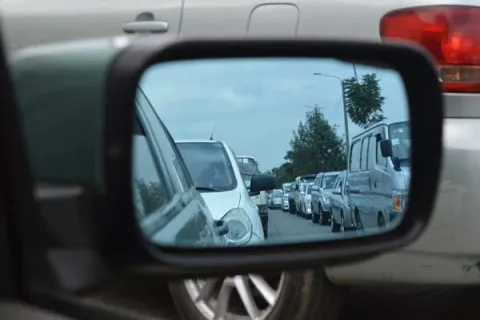 traffic on the highway in a rearview mirror