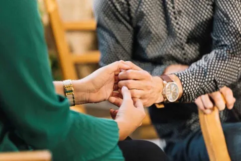 two people holding hands in support of each other