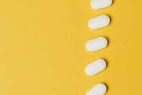 white pills on a yellow surface