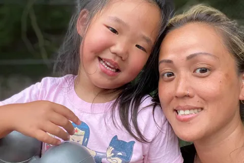 woman with a nose ring and young girl in a pink shirt