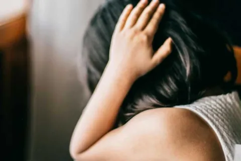 young girl anxiously covering her ears