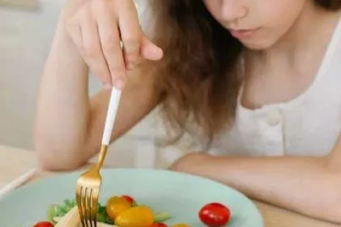 young girl eating a small salad