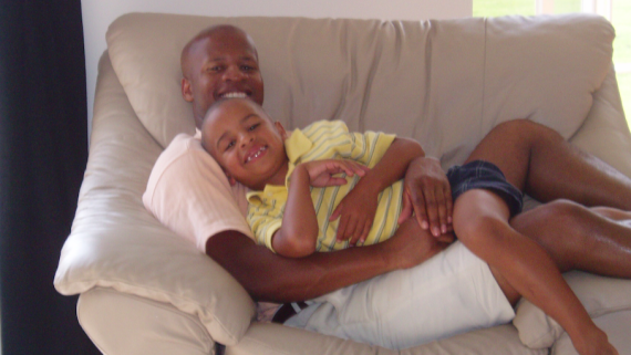 NASCAR driver Armani Williams as a child hugging his dad, Del, on the couch