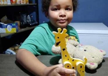 Brandon holding a wooden giraffe toy