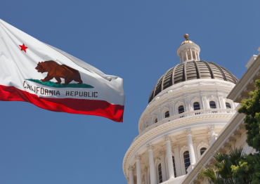 photo of California state flag next to capitol dome