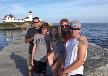 Kathy Hooven and her family in front of a lighthouse