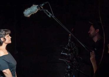 Rose L. on set while being filmed with a microphone above her head