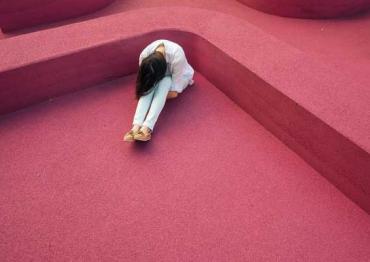 Woman with her head down in a pink room