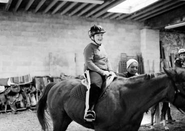 child riding a horse as a form of equine therapy for autism