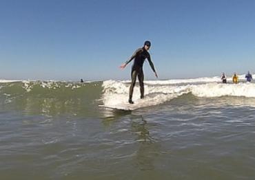 a man wearing a black wetsuit while surfing in the ocean