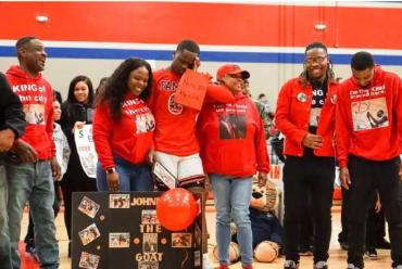 A basketball player in a red jersey cries with his sister for support during an autism celebration 