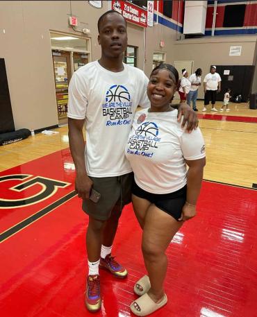 A brother and a sister stand in the middle of a basketball court 