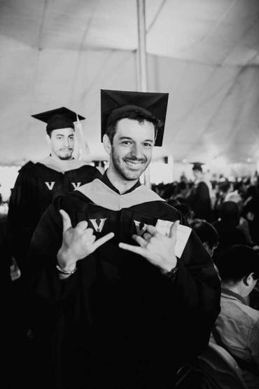 Alex smiling and walking at graduation