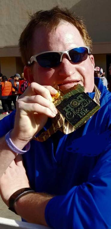 Andy holding a metal after a 15k race