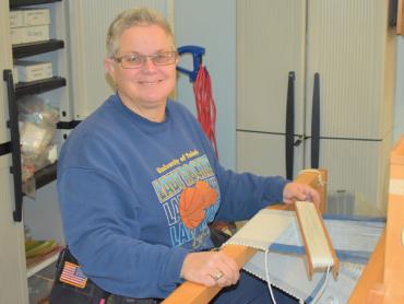 Beth weaving at a desk