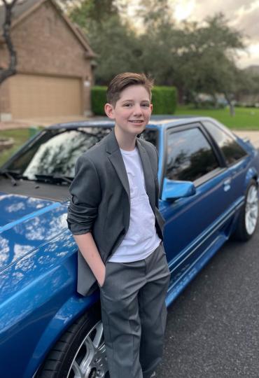 Blake standing next to a blue car