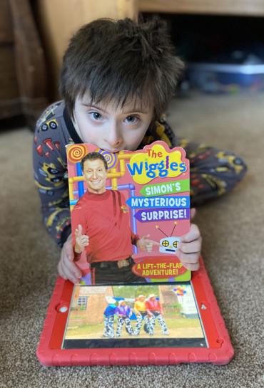 Boston holding a book about The Wiggles