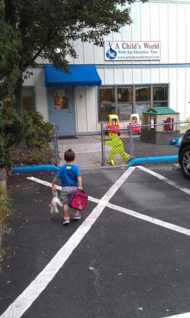 Chase walking into school with a backpack and stuffed animal