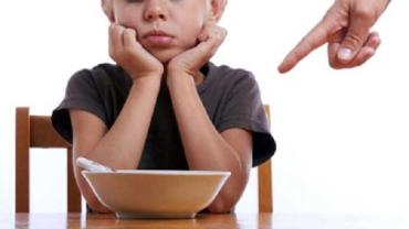 Child in front of a bowl of food that they don't want to eat