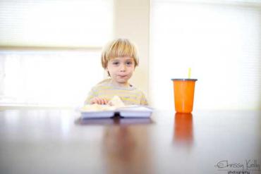 Chrissy Kelly's young son with blonde hair sitting at the table for a meal