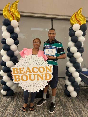 DJ and his mom holding a sign that says Beacon Bound