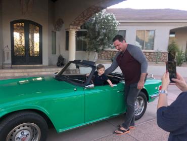 Dave and his grandson in a green convertible