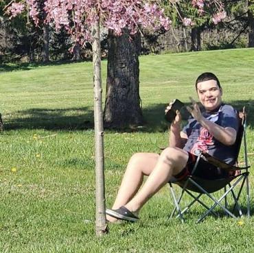 Guarionex sitting in fold out chair in park