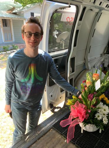 John Varnedoe loading a floral arrangement into a truck