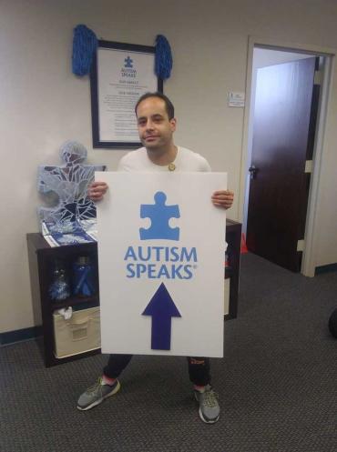 Jon Delancy holding an Autism Speaks sign