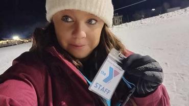 Kayla C. holding her YMCA staff badge