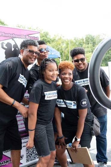 Kimacka Randle, her husband and three kids standing in front of ring light to take a group photo