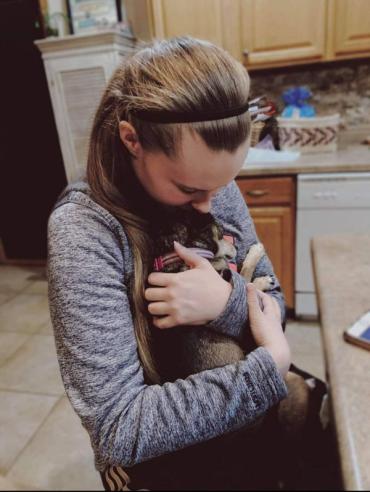 Mariah Kay hugging a small dog