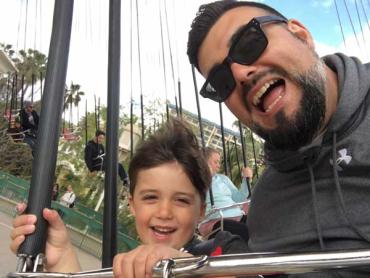 Nick Wright and his son on an amusement park ride