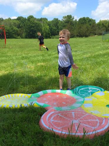 Noal playing outside with a water toy