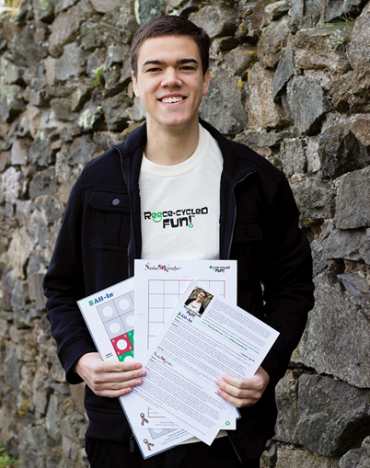 Reece Arnold holding up papers in front of a stone wall