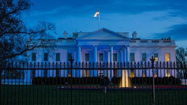 The White House with blue lighting at night to support autism
