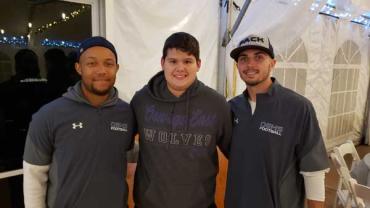 Three men wearing OEHS football shirts