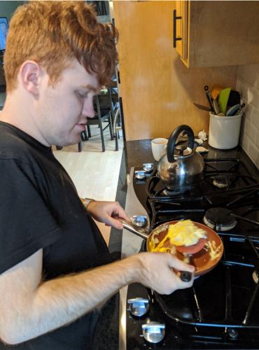 Tom in the kitchen cooking eggs