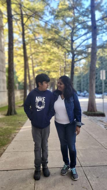 Tulika and Vedant walking on a sidewalk