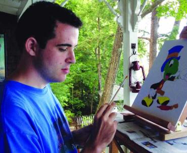 a man wearing a blue shirt and painting