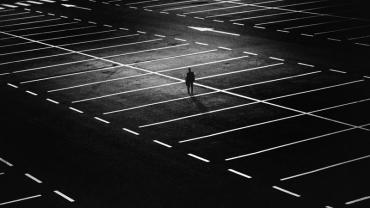 a person walking alone in an empty parking lot