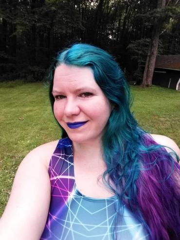 a woman with blue and purple hair, purple lipstick and a purple shirt