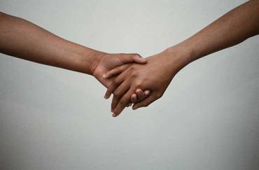 close up of two people holding hands