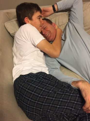 Stephen hugging his dad on the couch