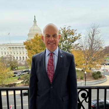 Stuart Spielman standing on balcony with Capitol building in background