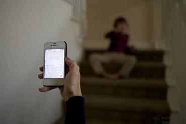 timer on an iPhone as a child sits on steps