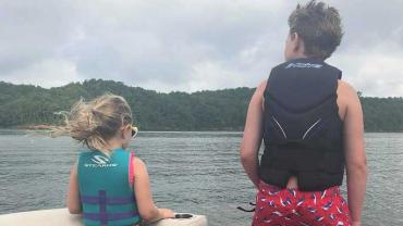 two children on a boat wearing life jackets